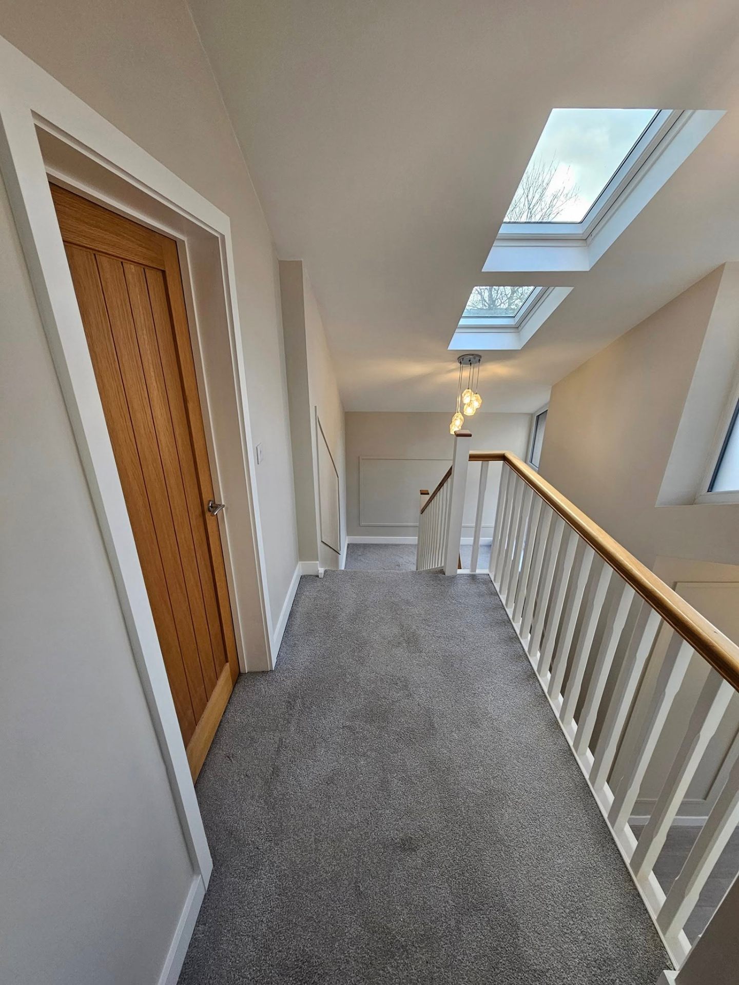 Bright upstairs hallway in soft greige with new oak doors — South Wales interior decorating