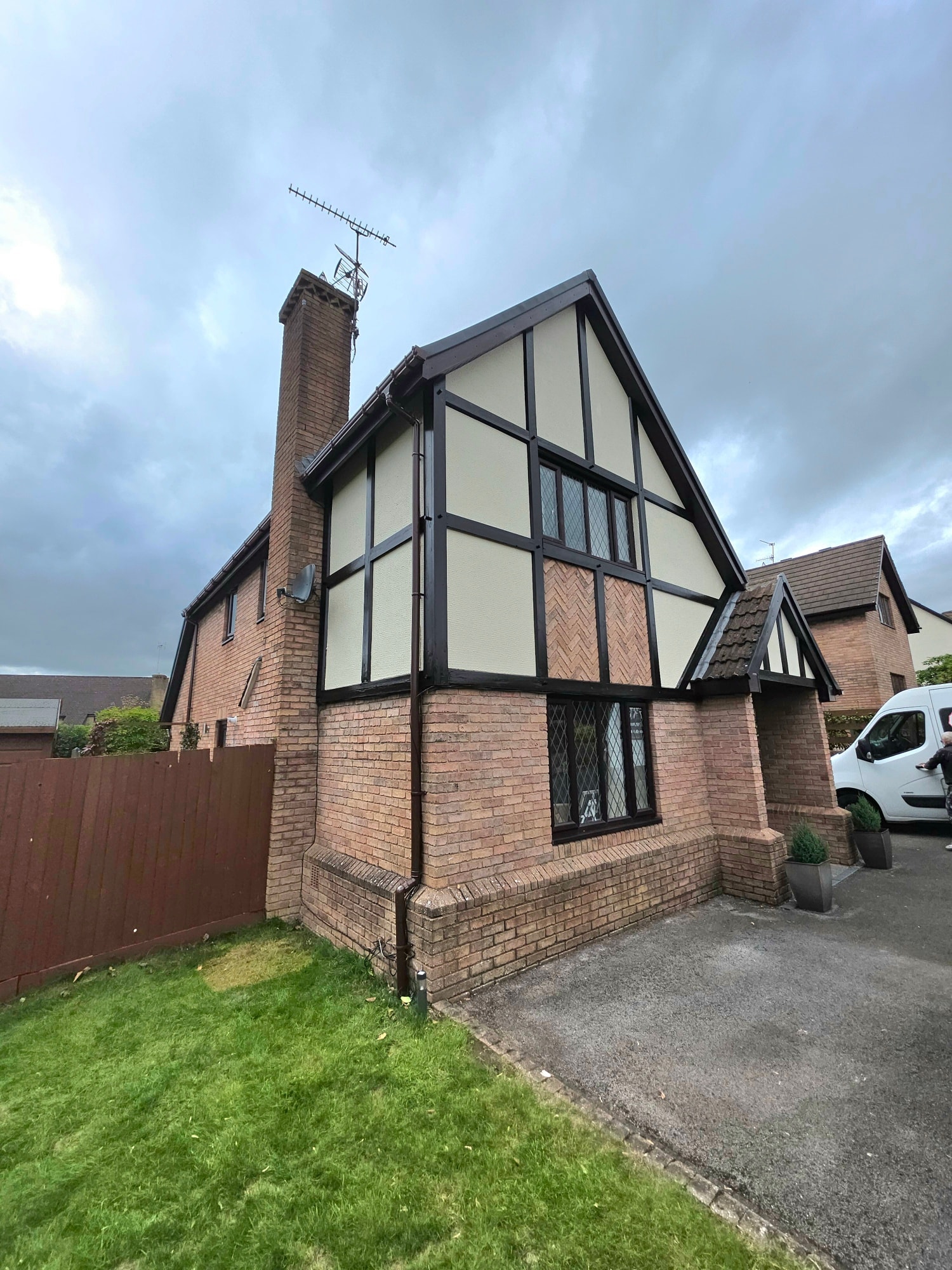 Side elevation of repainted Tudor-style detached property in South Wales