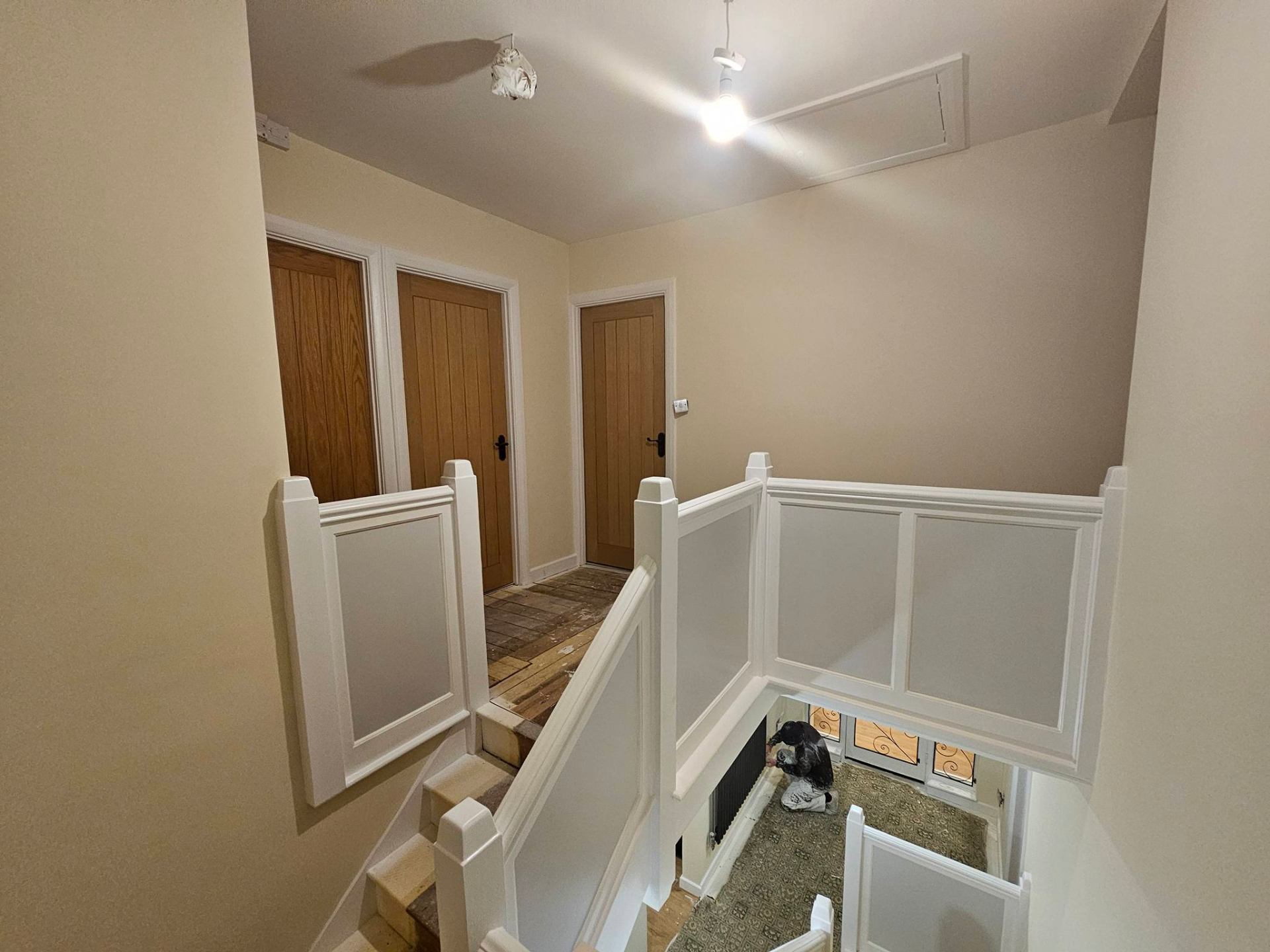 Open hallway and stair area in a soft modern neutral after full repaint