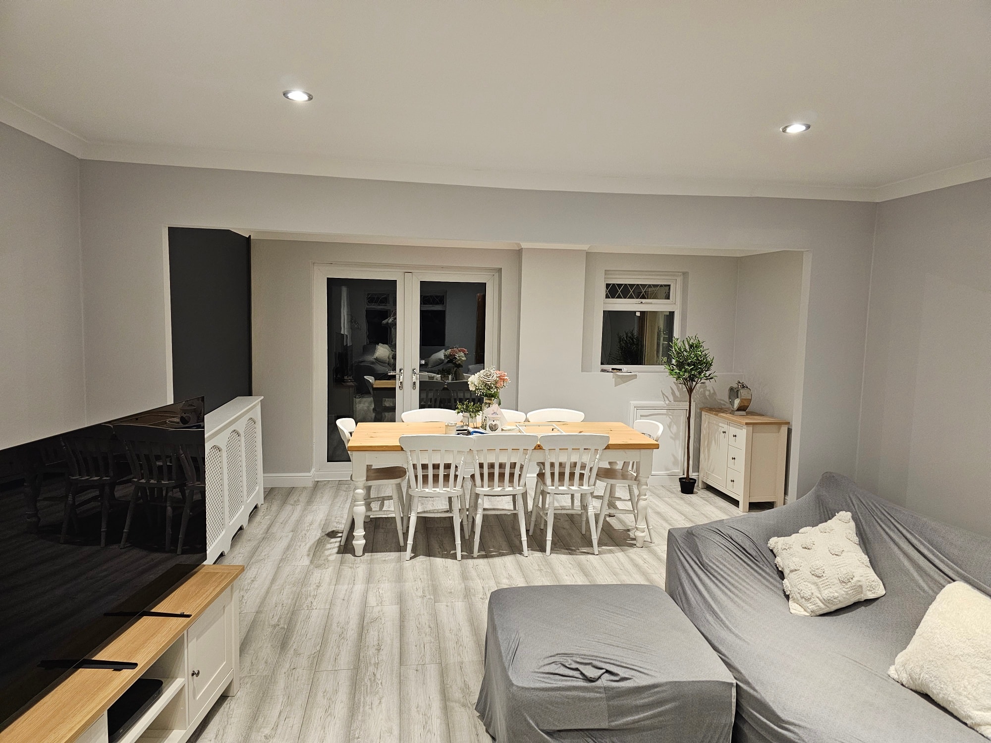 Open plan dining and lounge with subtle dark feature panel