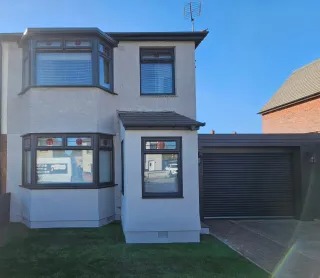 Recently repainted grey-render home with garage in South Wales